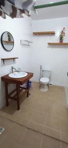 uma casa de banho com um lavatório e um WC em CocoHut Beach House em Locaroc