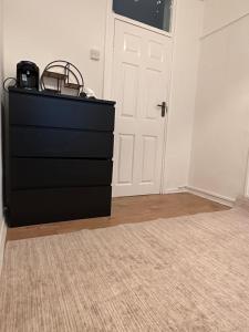 a black dresser in a room with a door at Spacious Private Room in the heart of Dalston, Hackney in London