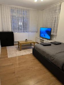 a bedroom with a bed and a flat screen tv at Spacious Private Room in the heart of Dalston, Hackney in London