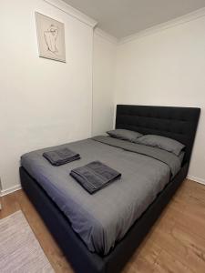 een slaapkamer met een bed met twee handdoeken erop bij Spacious Private Room in the heart of Dalston, Hackney in Londen