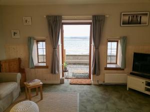 sala de estar con vistas al océano en St Brighs, en Dingwall