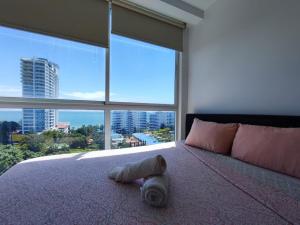 1 dormitorio con 1 cama grande y ventana grande en Apartamentos en Playa Coronado, en Playa Coronado