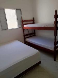 two bunk beds in a room with a window at Recanto Mar Rico in Boracéia