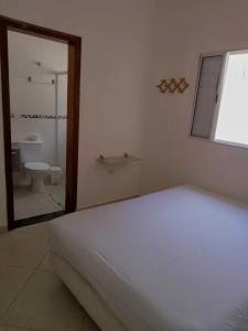 a bedroom with a bed and a bathroom with a toilet at Recanto Mar Rico in Boracéia