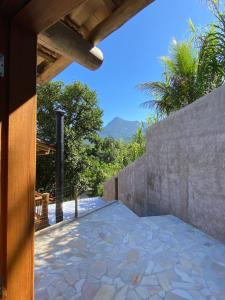 a patio of a house with a stone wall at Chalé do Joca in Ilhabela