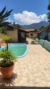 a swimming pool in a yard with a house at Chale Cantão de Itamambuca in Ubatuba