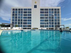 una piscina con dos edificios altos en el fondo en Apartamentos en Playa Coronado en Playa Coronado