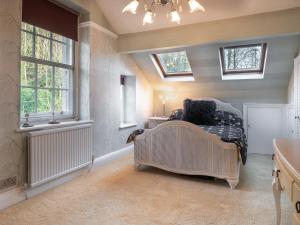 um quarto com uma cama num quarto com janelas em Orrest Howe em Windermere