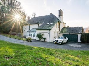 a white car parked in front of a house at Orrest Howe in Windermere