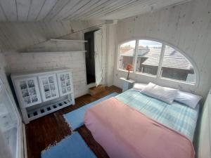 um quarto com uma cama num quarto com uma janela em Casa beiramar, solar, barulho do mar, pé na areia! em Xangri-lá