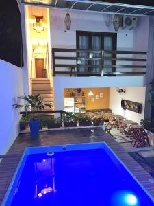a blue swimming pool in front of a house at Pousada Bilica - Centro in Arraial d'Ajuda