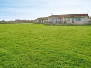 a large field of green grass in front of a house at Roses Place in Bacton