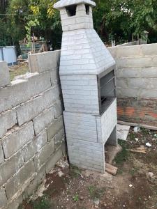 un horno de ladrillo sentado junto a una pared de ladrillo en N8 Casa 2 Dorm Zona Residencial Barrio Villa Lola Artigas en Artigas