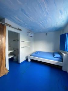 a blue room with a bed and a blue ceiling at Hostal Coral Blue in Rincón