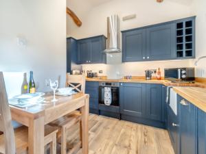 WesterdaleにあるLittle Esklets - Uk45252のキッチン(青いキャビネット、木製テーブル付)
