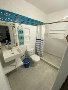 a bathroom with a white toilet and a sink at Hostal Coral Blue in Rincón