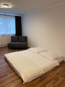 a bedroom with a large bed and a chair at Schönes Apartment in Messe Nähe in Nürnberg