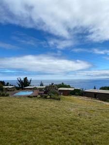 a field of grass with a view of the ocean at Cabañas Lovel-Van in Curanipe