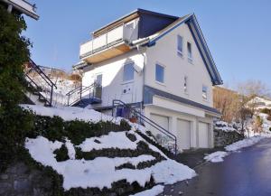 uma casa branca com neve ao lado em Ferienwohnung Bergzauber 2 (inkl. MeineCardPlus) em Willingen