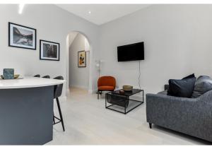 a living room with a couch and a tv on a wall at Captivating 2 BD Flat in London in London