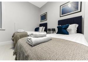 a bedroom with two beds with towels on a bed at Captivating 2 BD Flat in London in London