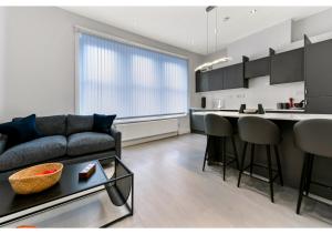 a living room with a couch and a kitchen at Captivating 2 BD Flat in London in London