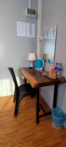 a desk with a chair and a table with a lamp at Guest House Gua Kelam in Kaki Bukit