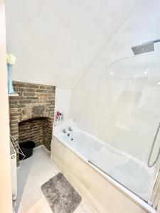 a bathroom with a bath tub and a fireplace at Gundulph house in Rochester