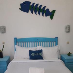 un letto con testiera blu e un pesce sopra di esso di Ruis Place a Vila Praia Do Bilene