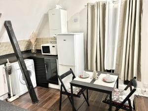 a kitchen with a table and chairs and a microwave at Gundulph house in Rochester