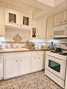 a kitchen with white cabinets and a stove top oven at Charming Two Story Country Style Loft with Balcony in Houston