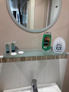 a bathroom sink with a mirror and a green bottle of cleaner at The Noel At Whitwell 