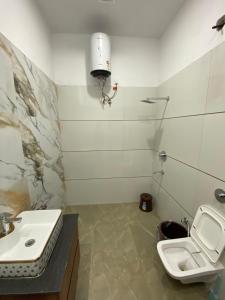 Un baño blanco con lavabo e inodoro. en Amritsar Homes - A perfect home away from home, en Amritsar 10 fotos más