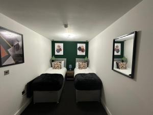 ein kleines Zimmer mit 2 Betten und 2 Spiegeln in der Unterkunft Newark House Premium Apartments by DH ApartHotels in Peterborough