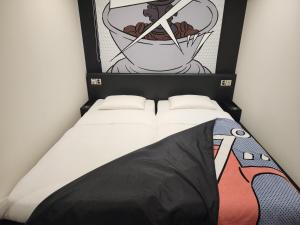 東京にあるHOTEL TAVINOS Hamamatsuchoの壁画が飾られた部屋のベッド1台