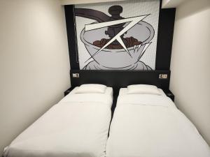 duas camas num quarto com uma fotografia na parede em HOTEL TAVINOS Hamamatsucho em Tóquio