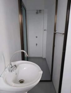 een witte wastafel in een badkamer met een douche bij Barrett Accommodation Budget Rooms in Suva