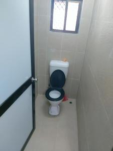 a small bathroom with a toilet with a window at Barrett Accommodation Budget Rooms in Suva