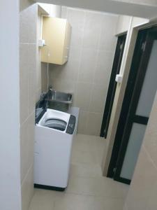 een kleine badkamer met een wastafel en een wasmachine bij Barrett Accommodation Budget Rooms in Suva