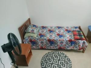 a bedroom with a bed and a table with a fan at Barrett Accommodation Budget Rooms in Suva