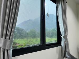 a window with a view of a mountain at Pada Guesthouse Khaoyai in Mu Si
