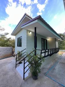 a small white house with a driveway at Pada Guesthouse Khaoyai in Mu Si