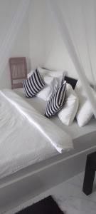 een wit bed met 2 kussens erop bij Ice Age Cottage in Ella