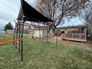 a playground with a black canopy in a yard at CozyLiving in Billings