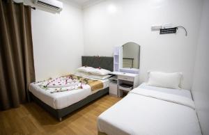 una camera d'albergo con due letti e uno specchio di iHaven Thulusdhoo a Thulusdhoo