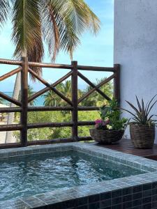 ein Pool vor einem Zaun mit Pflanzen in der Unterkunft VILA CORALLI CASA 05 in Passo de Camarajibe