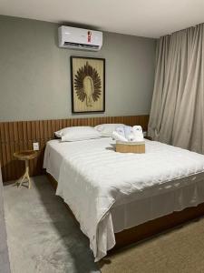 ein Schlafzimmer mit einem großen Bett mit weißer Bettwäsche in der Unterkunft VILA CORALLI CASA 05 in Passo de Camarajibe