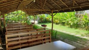 a church with wooden benches in a garden at Yayay Homestay in General Luna