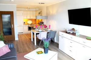 sala de estar con mesa y cocina en Norderhoog-Whg-38-1-OG-Wohnung-38, en Westerland