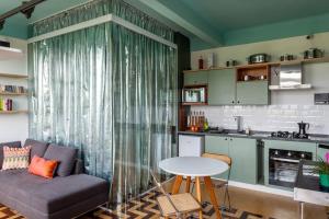 ein Wohnzimmer mit einem Sofa und einem Tisch sowie eine Küche in der Unterkunft Kit Rio - vista mais linda do RJ in Rio de Janeiro